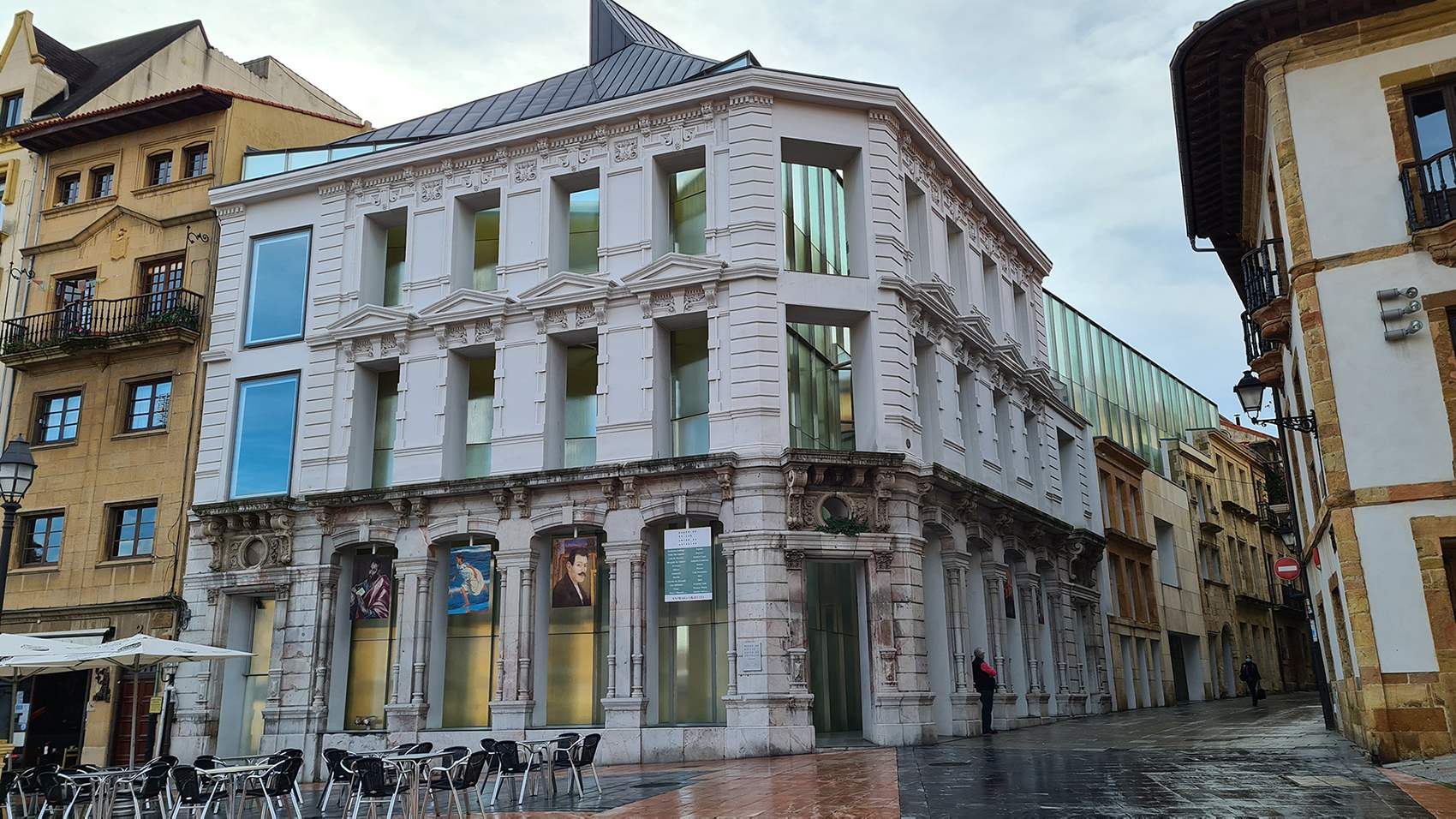 Fotografía de la entrada al museo de Bellas Artes de Oviedo, concretamente a la nueva ampliación donde se observa el edificio de fachada blanca articulada con ventanales y cristaleras que aportan gran luminosidad.