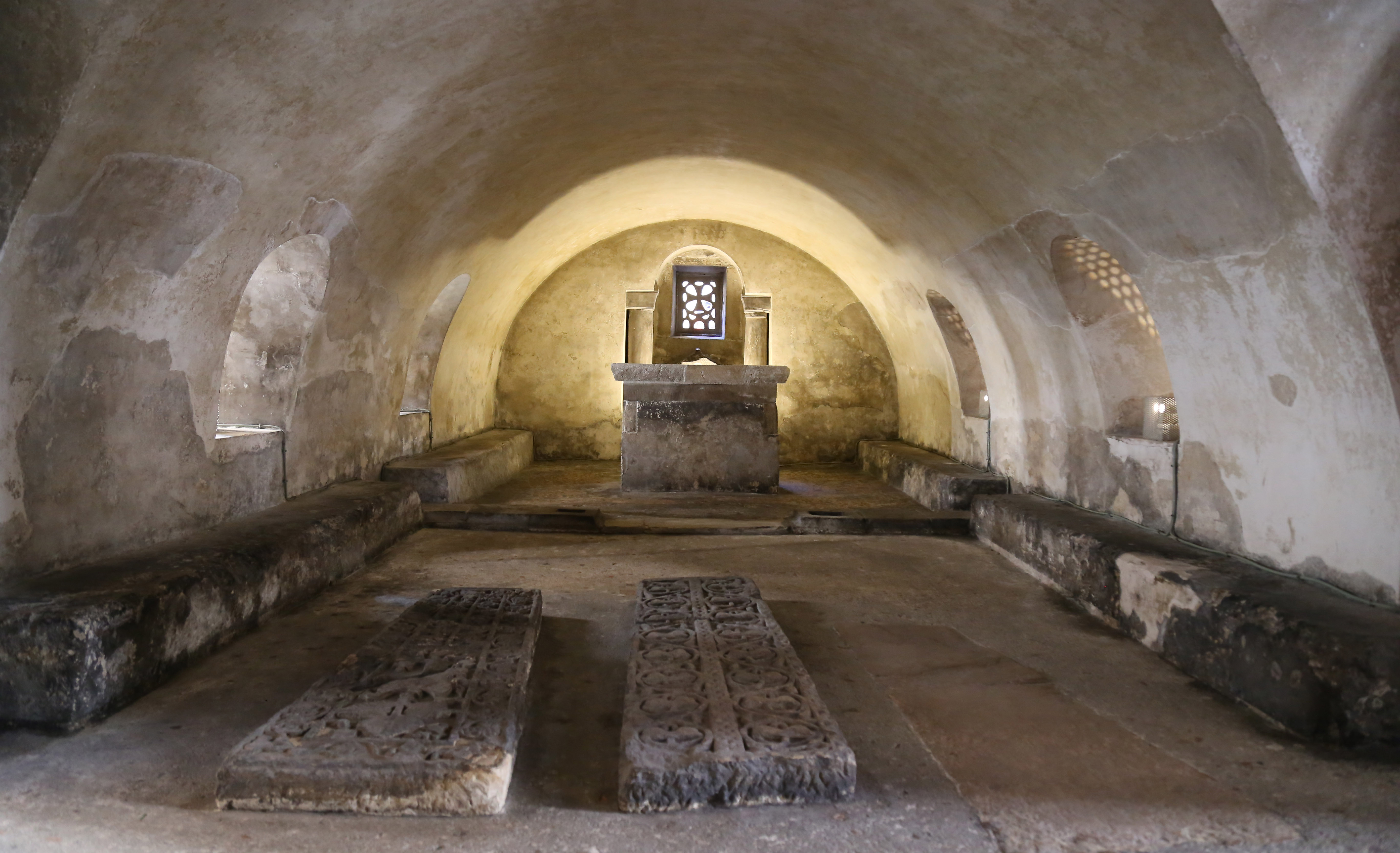 Foto de la cripta medieval de Santa Leocadia Cripta se observa desde un extremo su planta rectangular, la nave se compone de una bóveda de cañón, y al fondo un presbiterio, donde se sitúa el altar.