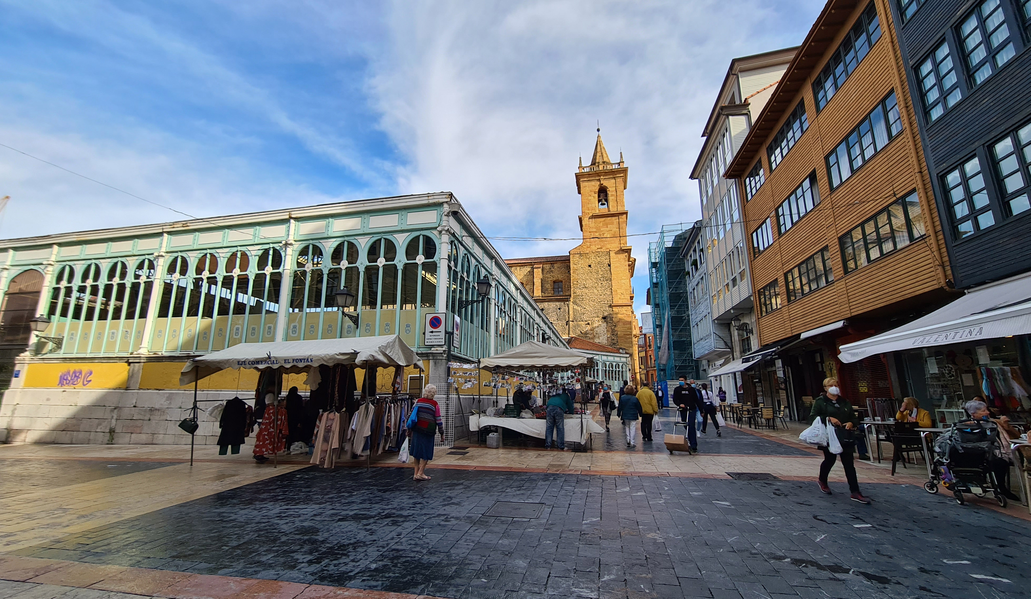 Foto de la plaza del Fontán, donde se pueden ver algunos puestos, la entrada al mercado, y de fondo la iglesia de San Isidoro el Real 