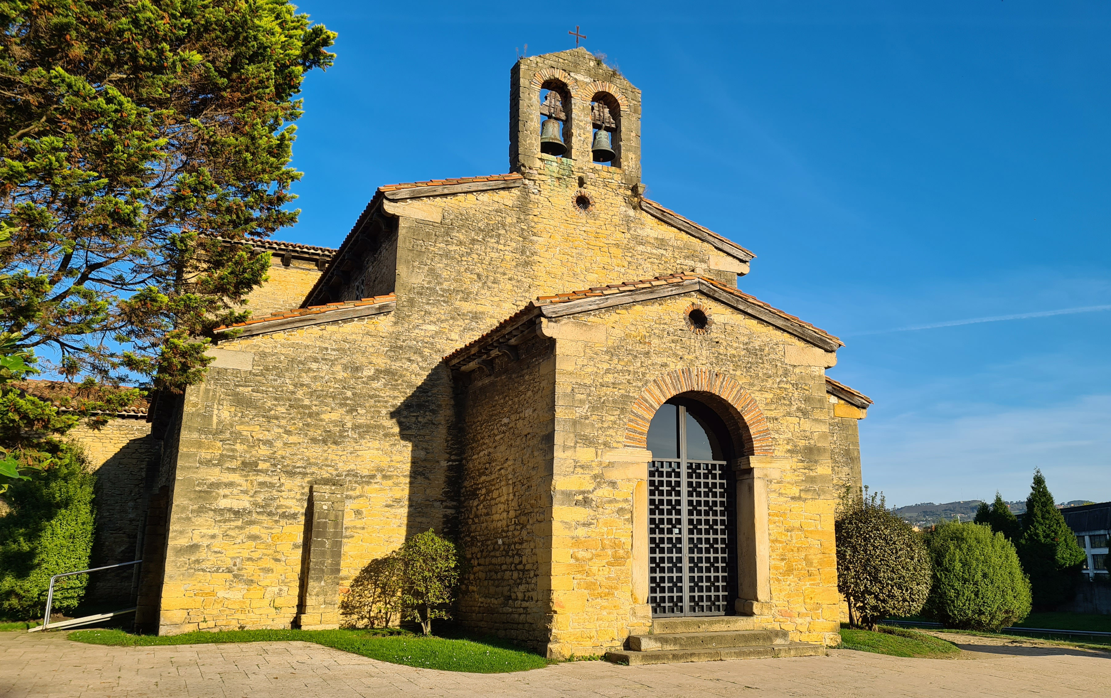 Fotografía de la iglesia prerrománica San Julián de los Prados, se observa un templo espacioso con planta basilical de tres naves separadas por pilares cuadrados que sostienen arcos de medio punto y transepto con remarcado alzado.