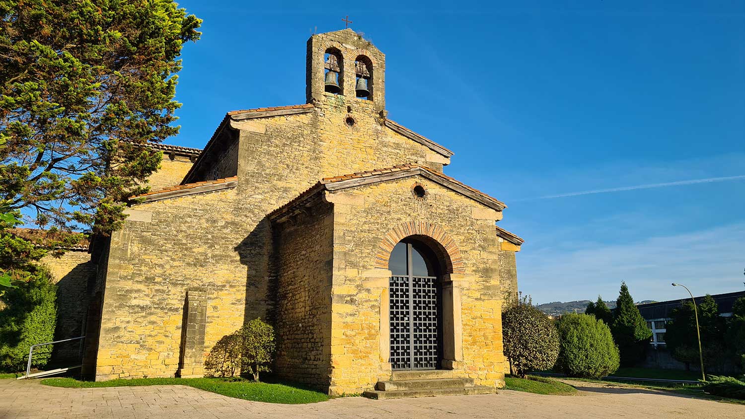 Fotografía de la iglesia prerrománica San Julián de los Prados, se observa un templo espacioso con planta basilical de tres naves separadas por pilares cuadrados que sostienen arcos de medio punto y transepto con remarcado alzado.